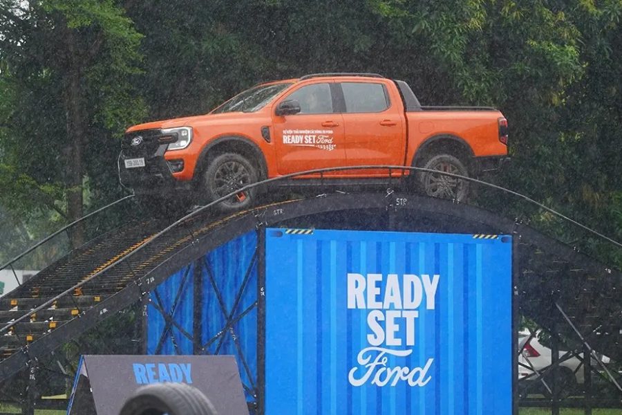Ford Ranger màu cam đứng trên cầu dốc thép cạnh container Ready Set Ford tại bãi lái thử