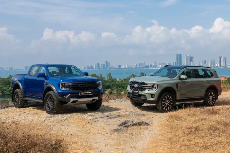 Ranger Raptor màu xanh, Everest màu xanh rêu và Ranger màu cam đỗ trên đồi nhìn ra thành phố ven biển